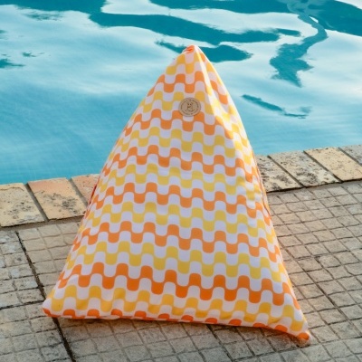 Almofada triangular colorida junto a uma piscina