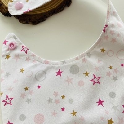 Babete de bebé branco com estrelas e círculos coloridos