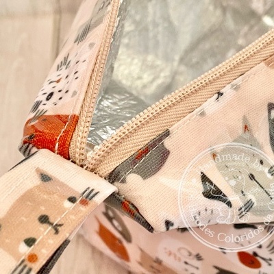 Saco térmico com padrão de gatos em tecido creme e fecho beige aberto