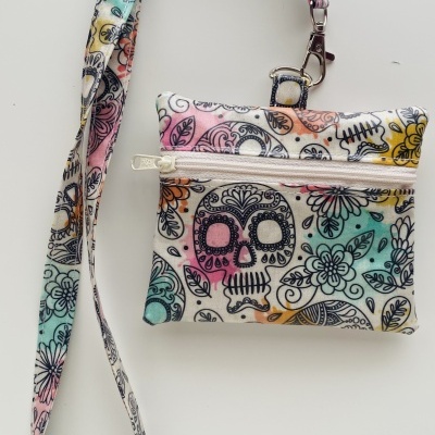 Bolsa pequena com padrão de caveiras e flores coloridas