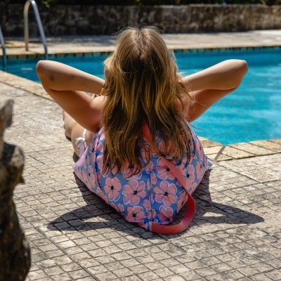 Mochila floral rosa e azul junto à piscina
