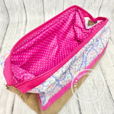 Estojo rosa e azul com padrão floral e interior rosa com pontos brancos