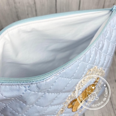 Porta-moedas branco acolchoado com fecho azul-claro e bordado decorativo