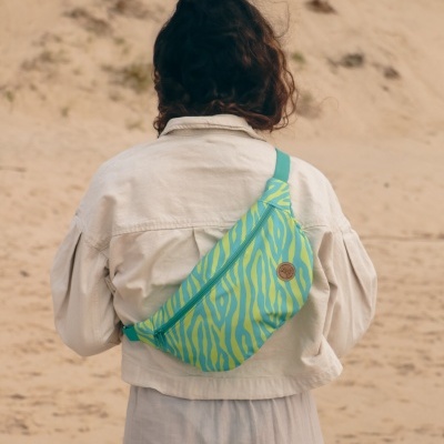Pochete verde com padrão amarelo zebrado na praia