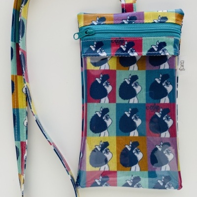 Bolsa pequena com padrão de cães coloridos e alça combinando