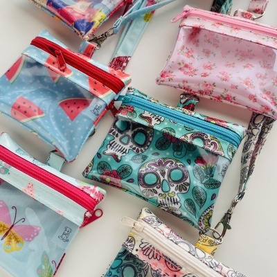 Sete bolsas pequenas transparentes com diferentes estampas e fechos coloridos