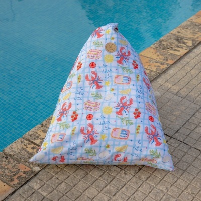 Pufe triangular colorido junto a uma piscina