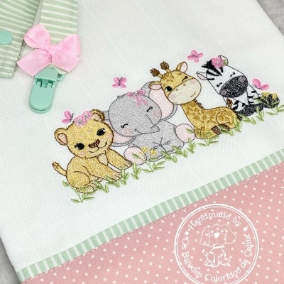 Toalha branca com bordado de animais bebés e faixa rosa às bolinhas com presilha verde e laço cor-de-rosa