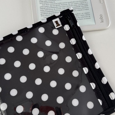 Leitor Kobo branco com capa protetora preta com bolinhas brancas.