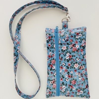 Bolsa pequena azul claro com padrão floral e fecho de correr