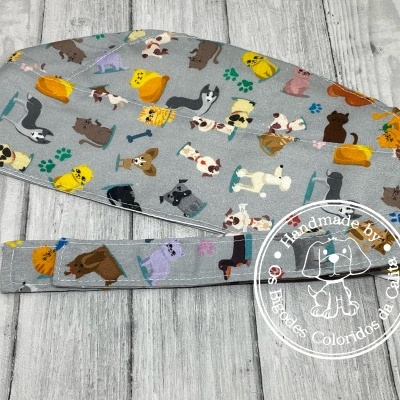 Touca e faixa com padrão de cães coloridos sobre fundo cinza