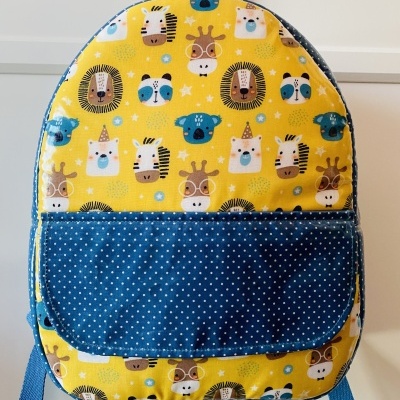 Mochila infantil amarela com desenhos de animais e bolso azul com pontos brancos