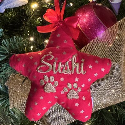 Enfeite de Natal vermelha em forma de estrela com o nome Sushi bordado e patas em tecido na árvore de Natal