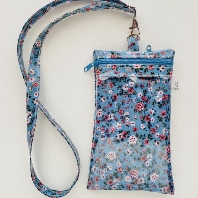 Bolsa pequena azul com padrão floral e bolsa transparente dianteira