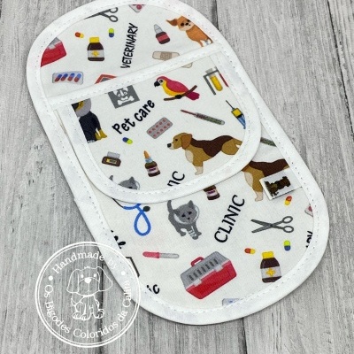 Tecido branco estampado com motivos veterinários e animais sobre madeira clara