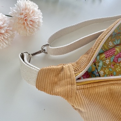 Mala de tecido camel com interior estampado e alça ajustável