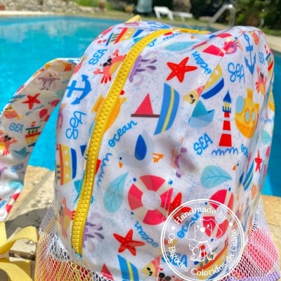 Mochila infantil colorida com tema náutico junto a piscina