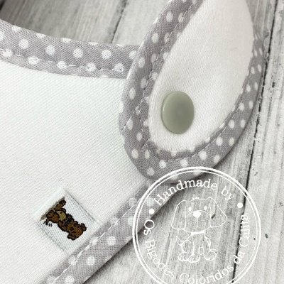 Babete branco com bordas cinzentas de bolinhas brancas e fecho de mola cinzento