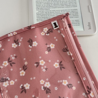 Capa rosa com flores brancas e amarelas sobre leitor Kobo branco com texto em português