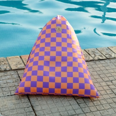 Almofada triangular laranja e roxa ao lado de piscina