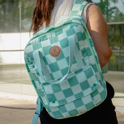 Mochila quadrada verde e branca com padrão xadrez sendo usada