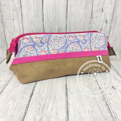 Estojo retangular castanho e azul com padrão floral e fecho rosa