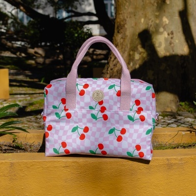 Mala rosa com padrão de cerejas e alças cor-de-rosa