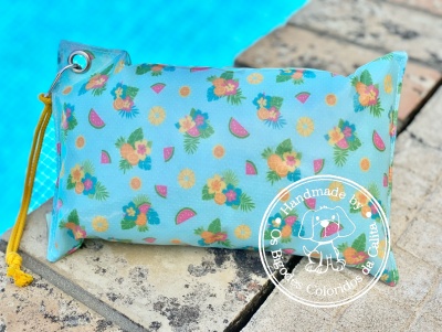 Estojo azul claro com padrão de flores e melancia junto à piscina