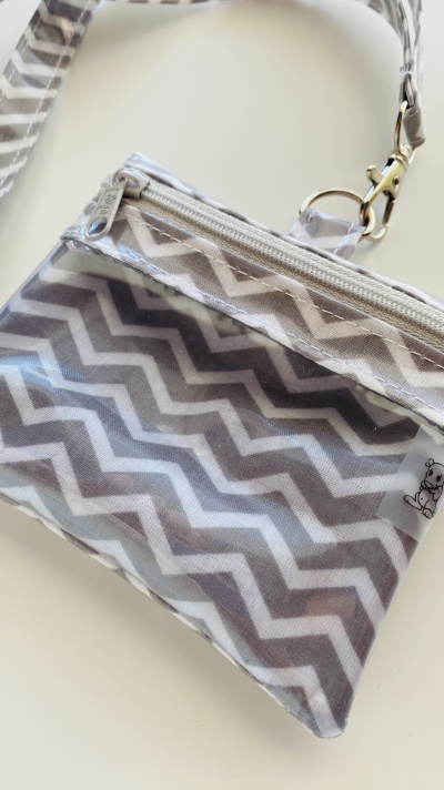 Bolsa pequena transparente com padrão de zig-zag cinza e branco e fecho de correr