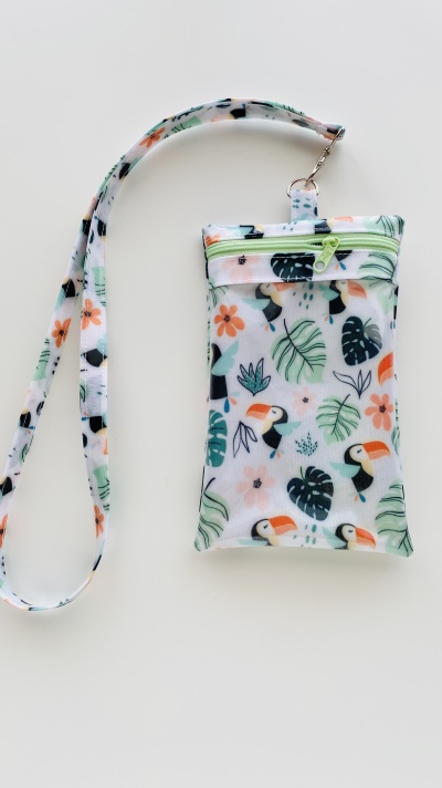 Bolsa pequena com padrão de tucanos e folhas em fundo branco com fita para pescoço