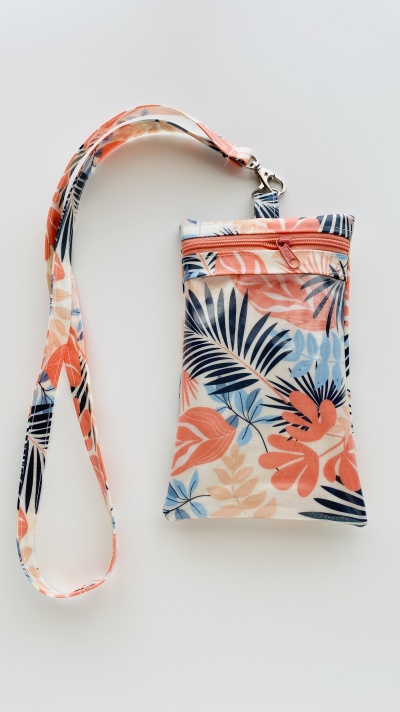 Bolsa pequena com padrão floral em tons de azul, laranja e bege com alça e fecho cor-de-rosa
