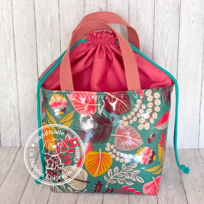 Saco térmico com padrão floral colorido, alças rosas e fecho de cordão cor-de-rosa