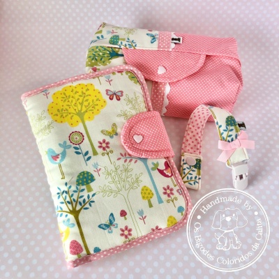 Conjunto em tecido para bebé com padrão de árvores, pássaros e borboletas, e detalhes rosa com bolinhas brancas