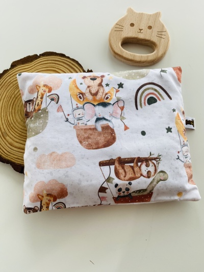 Almofada branca estampada com animais e brinquedo de madeira gato