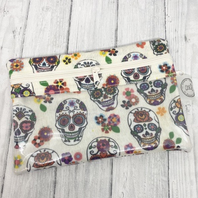 Estojo em tecido claro com padrão colorido de caveiras mexicanas e flores com fecho zip branco