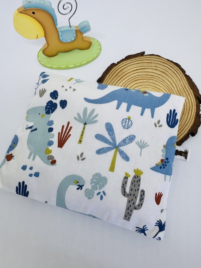 Almofada com padrões de dinossauros e plantas coloridas, suporte decorativo de dinossauro e madeira.