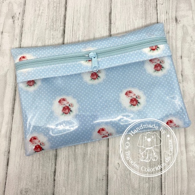 Necessaire azul claro com padrão de bolinhas e rosas vermelhas