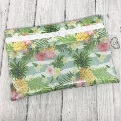 Estojo tecido com padrão tropical de abacaxis, flores e folhas verdes