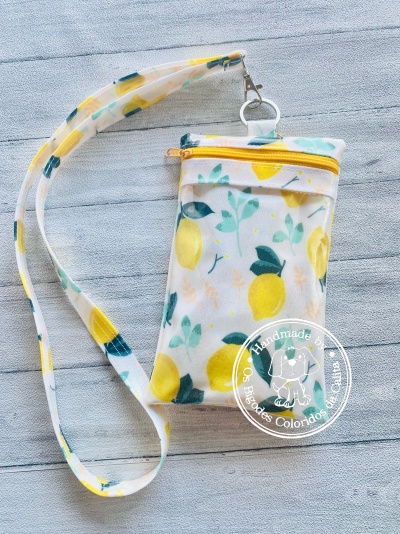 Bolsa pequena com padrão de limões e alça longa.