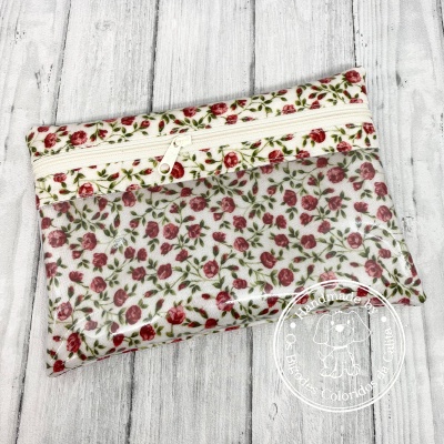 Bolsa pequena floral com fecho e capa plástica transparente com selo branco