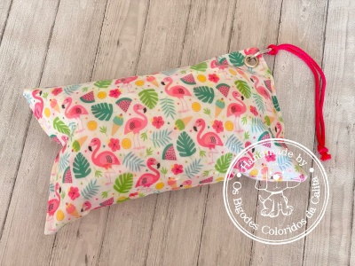 Estojo branco com padrão colorido de flamingos, folhas e flores e cordão vermelho