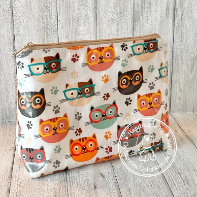 Necessaire estampada com gatos coloridos usando óculos