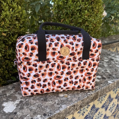 Mala animal print com alças pretas e etiqueta redonda com desenho de cão