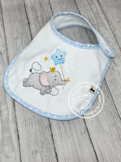 Babete de bebé branco com elefante e estrela bordados, com acabamento azul claro às bolinhas