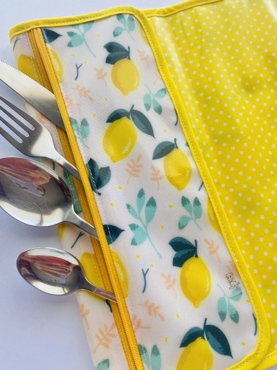 Estojo amarelo com talheres e padrão de limões e folhas