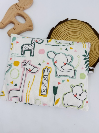 Almofada com padrão de animais coloridos em fundo branco, figura de madeira e base redonda de madeira