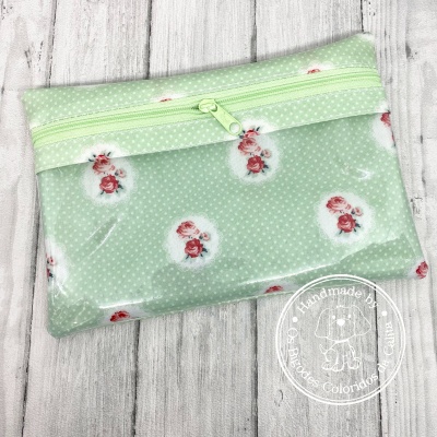 Estojo verde claro com padrão de flores e bolinhas brancas, com fecho de correr