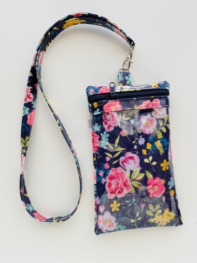 Bolsa pequena vai azul escuro com padrão floral colorido e alça para pendurar ao pescoço
