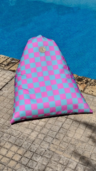 Pouf triangular rosa e azul junto à piscina
