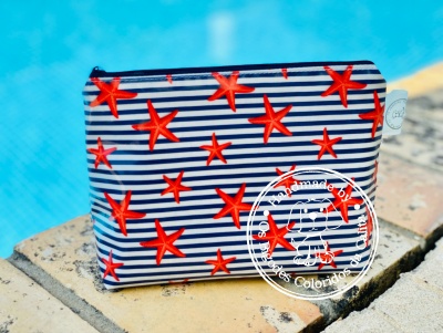 Necessaire com riscas azuis e brancas e estrelas-do-mar vermelhas junto a piscina